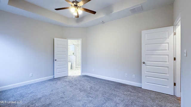 unfurnished room featuring carpet, a tray ceiling, and ceiling fan