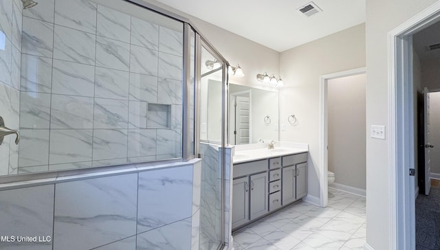 bathroom featuring vanity, toilet, and a shower with shower door