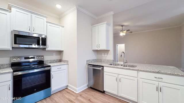 kitchen featuring light stone countertops, stainless steel appliances, ceiling fan, sink, and white cabinets