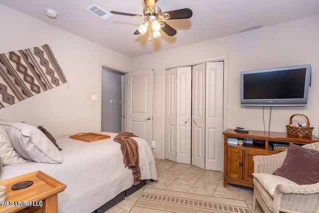 tiled bedroom featuring ceiling fan and a closet