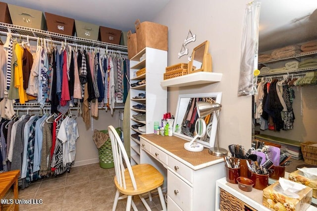 walk in closet with light tile patterned floors