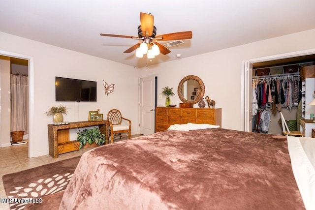 bedroom with ceiling fan, light tile patterned flooring, and a closet