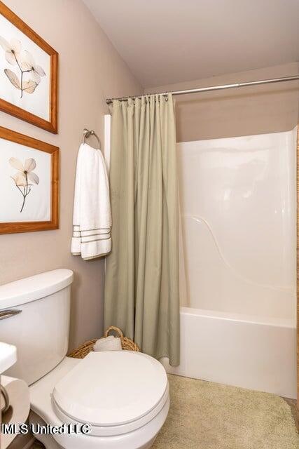 bathroom featuring toilet, lofted ceiling, and shower / tub combo with curtain