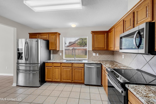 20 Lakeview Dr, Ocean Springs, MS 39564 - kitchen with appliances with stainless steel finishes, brown cabinetry, light stone countertops, backsplash, and light tile patterned floors