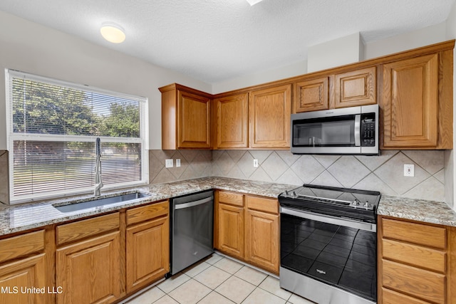 20 Lakeview Dr, Ocean Springs, MS 39564 - kitchen featuring appliances with stainless steel finishes, tasteful backsplash, light stone countertops, brown cabinets, and a textured ceiling