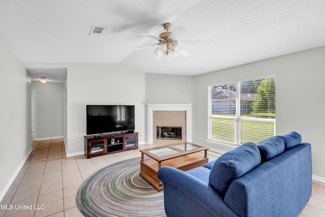 20 Lakeview Dr, Ocean Springs, MS 39564 - living room with light tile patterned flooring, a ceiling fan, a textured ceiling, a tiled fireplace, and lofted ceiling