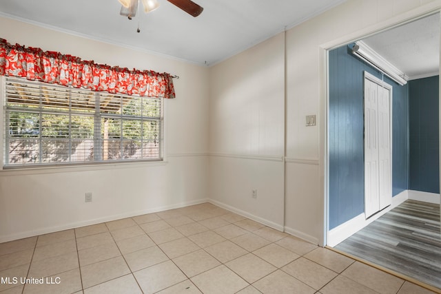 tiled spare room with crown molding and ceiling fan