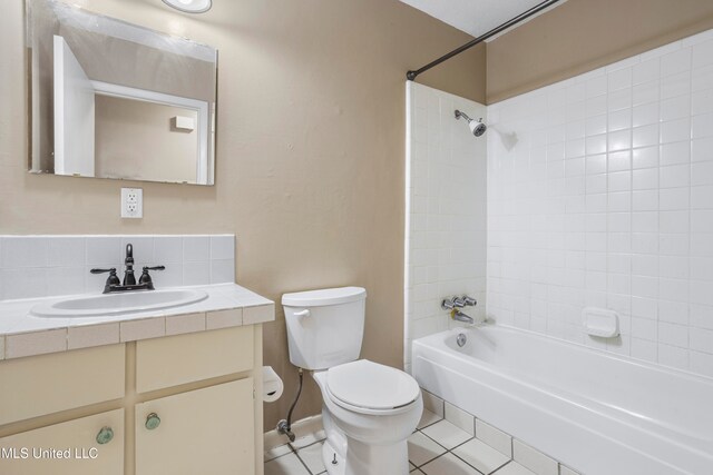 full bathroom featuring tiled shower / bath, decorative backsplash, tile patterned flooring, vanity, and toilet