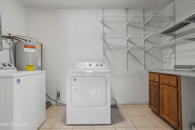 laundry area featuring separate washer and dryer, light tile patterned floors, and water heater