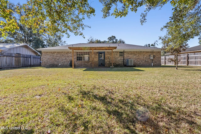 rear view of property with a yard and central air condition unit