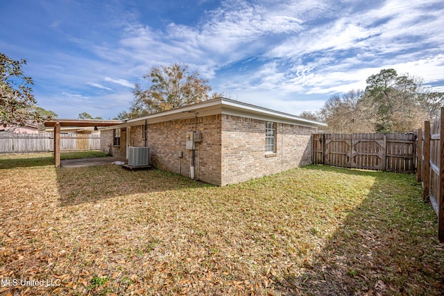 back of property featuring a lawn, a patio, and central air condition unit