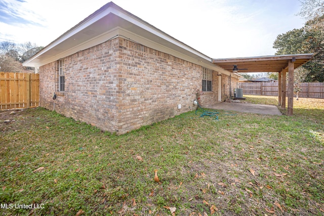 view of side of property featuring a patio, central AC unit, and a lawn