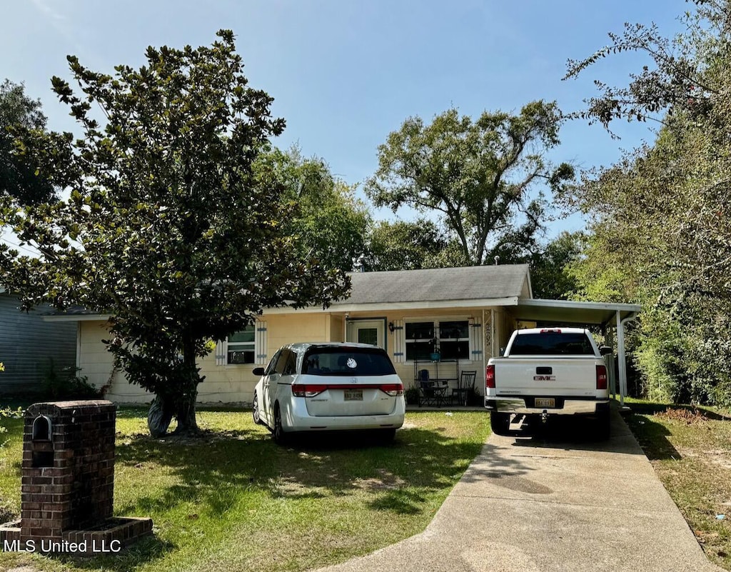 view of front facade featuring a carport and a front yard