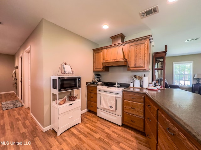 1104 SE 2nd St, Magee, MS 39111 - kitchen with black microwave, electric range, brown cabinets, light wood-style floors, and recessed lighting