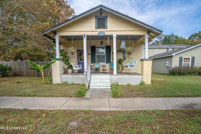 bungalow-style house with ceiling fan, a porch, and a front lawn