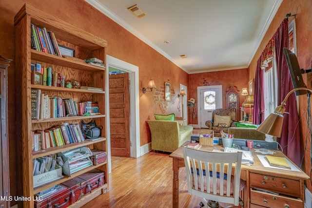 home office featuring light hardwood / wood-style floors and ornamental molding