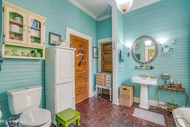 bathroom featuring ornamental molding, wooden walls, and toilet