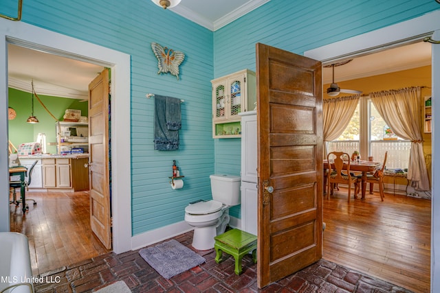 bathroom with lofted ceiling, crown molding, wood-type flooring, and toilet