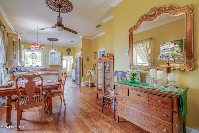 dining area with ceiling fan, ornamental molding, light hardwood / wood-style flooring, and a baseboard heating unit