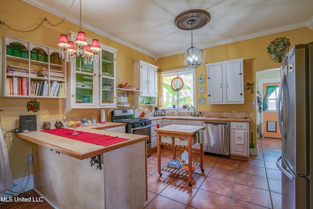 kitchen with a breakfast bar, appliances with stainless steel finishes, kitchen peninsula, and decorative light fixtures