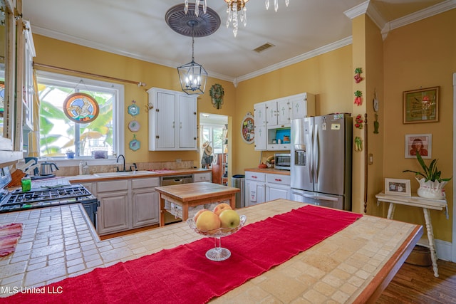 kitchen with white cabinetry, a healthy amount of sunlight, stainless steel appliances, and hanging light fixtures