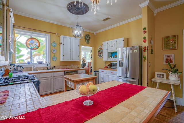 3508 11th St, Gulfport, MS 39501 - kitchen with stainless steel appliances, a sink, tile countertops, ornamental molding, and white cabinets