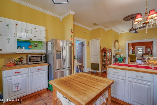3508 11th St, Gulfport, MS 39501 - kitchen featuring stainless steel appliances, a chandelier, white cabinets, and ornamental molding