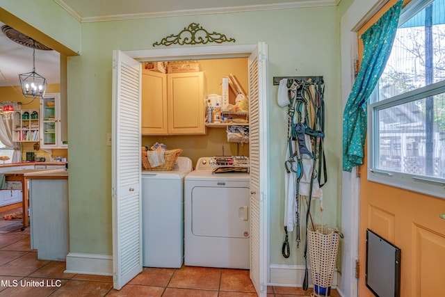 laundry room with cabinets, light tile patterned floors, an inviting chandelier, washer and dryer, and ornamental molding