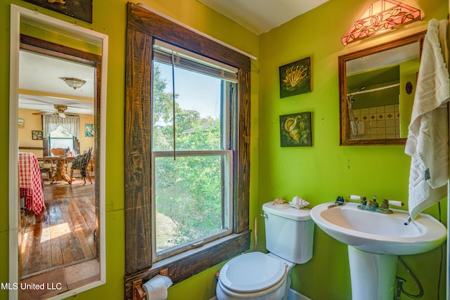 bathroom featuring a healthy amount of sunlight, hardwood / wood-style flooring, toilet, and ceiling fan