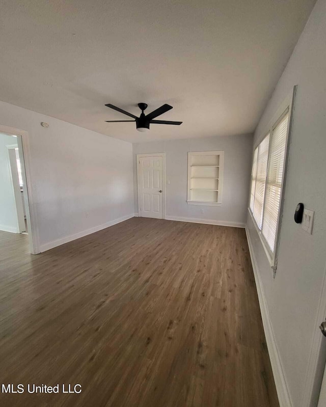 interior space featuring ceiling fan, built in features, and dark hardwood / wood-style flooring