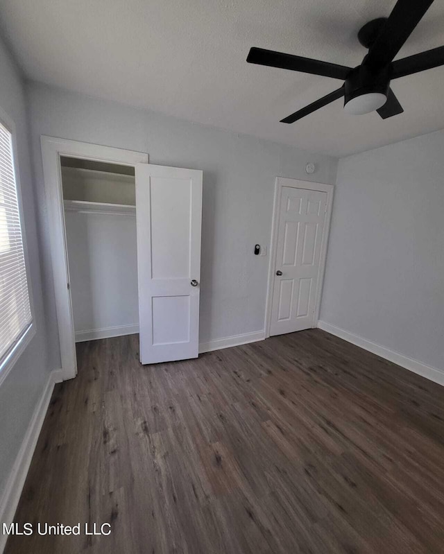 unfurnished bedroom with a textured ceiling, dark hardwood / wood-style floors, a closet, and ceiling fan