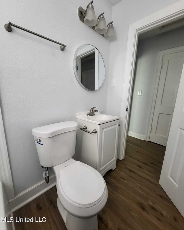 bathroom with vanity, wood-type flooring, and toilet