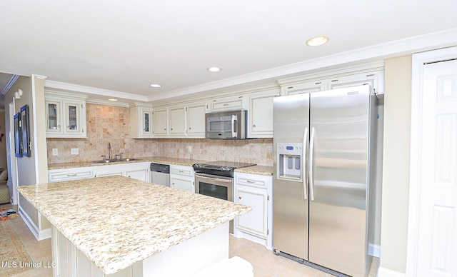 65 Breakers Ln, Ridgeland, MS 39157 - kitchen featuring stainless steel appliances, a sink, light tile patterned flooring, a center island, and decorative backsplash