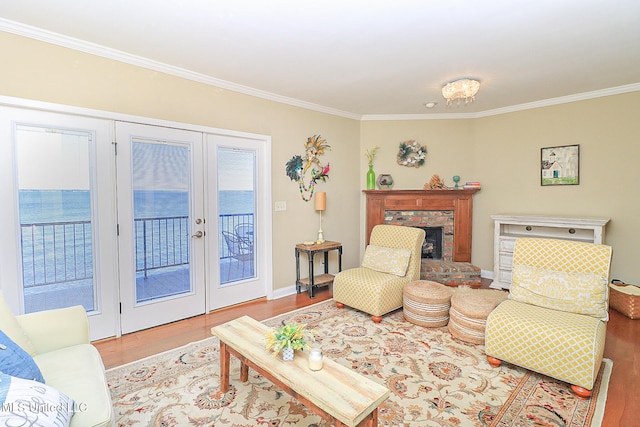 living room with crown molding, light hardwood / wood-style flooring, and a water view