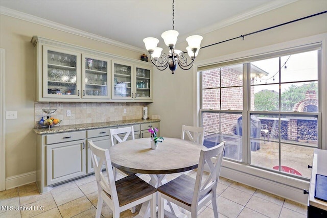 208 Grand Oak Blvd, Clinton, MS 39056 - dining space with baseboards, ornamental molding, a notable chandelier, and light tile patterned flooring