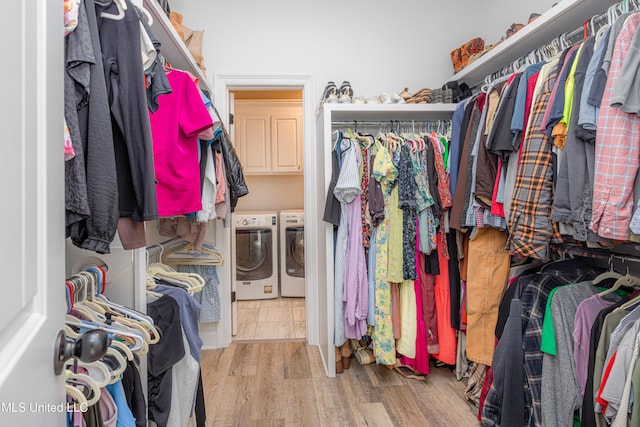 spacious closet featuring washer and clothes dryer and light wood-type flooring