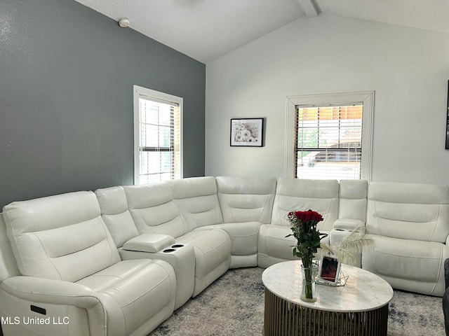 living room featuring a wealth of natural light, light carpet, and vaulted ceiling with beams