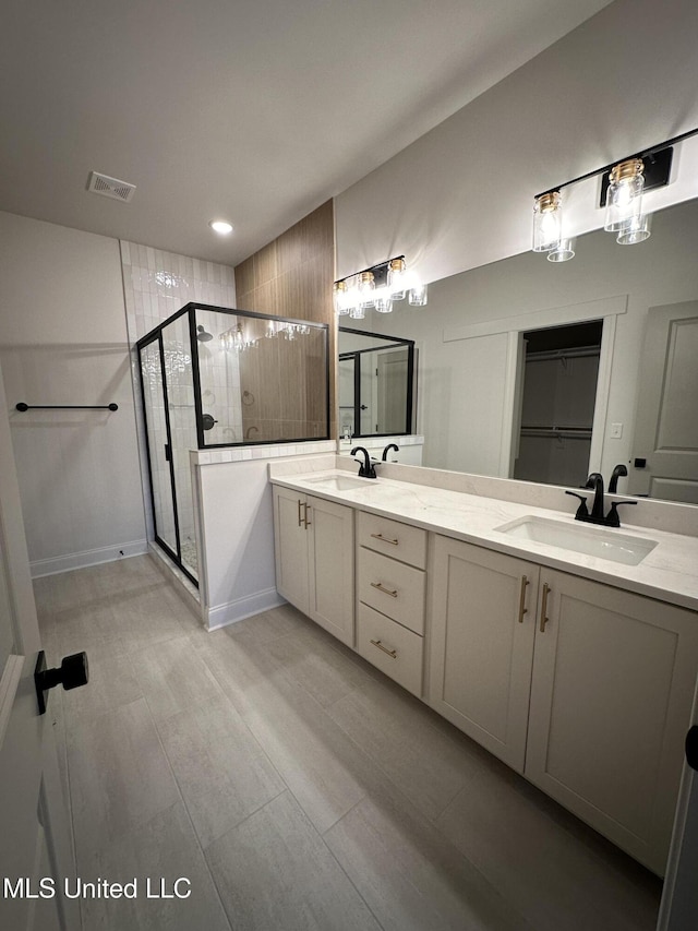 full bath featuring a shower stall, double vanity, and recessed lighting
