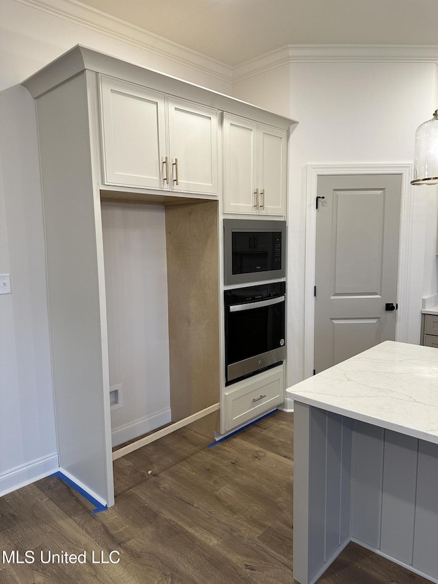 kitchen with stainless steel oven, black microwave, light stone counters, dark wood-style flooring, and ornamental molding