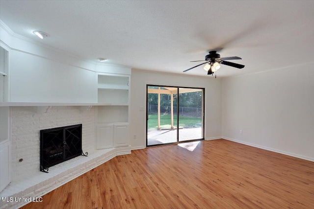 603 Herndon Hl, Clinton, MS 39056 - unfurnished living room featuring a ceiling fan, light wood finished floors, a brick fireplace, baseboards, and built in shelves