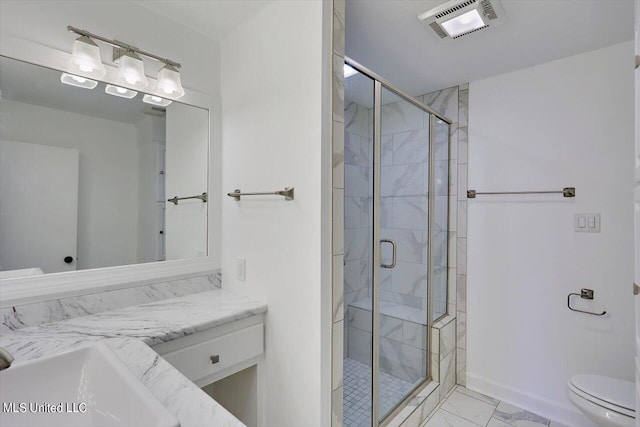 bathroom with vanity, toilet, and a shower with shower door