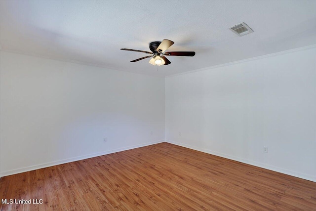 spare room with ceiling fan, crown molding, and hardwood / wood-style floors