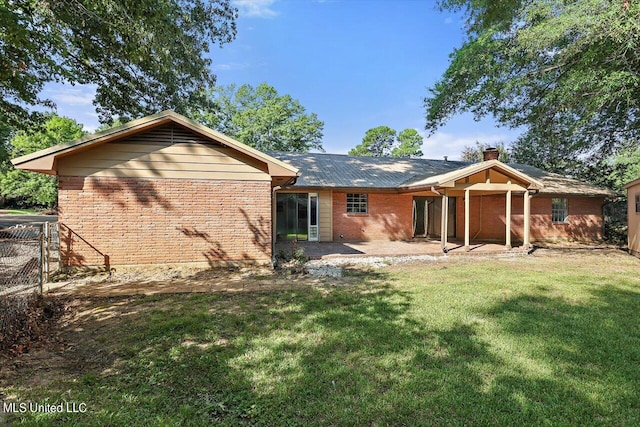 rear view of house featuring a patio and a lawn