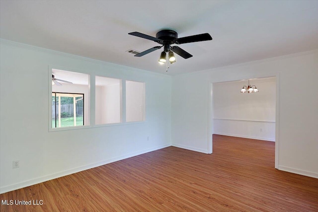 spare room featuring crown molding, hardwood / wood-style flooring, and ceiling fan with notable chandelier