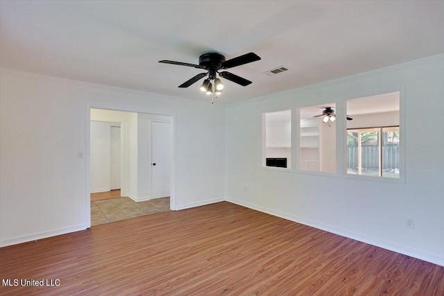 empty room featuring ornamental molding, light hardwood / wood-style floors, and ceiling fan