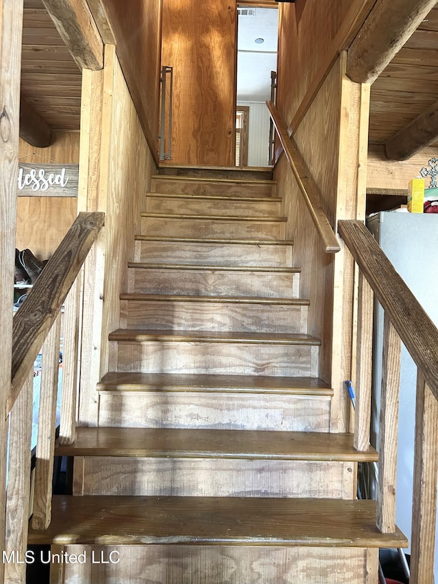 stairs featuring wooden walls and wooden ceiling