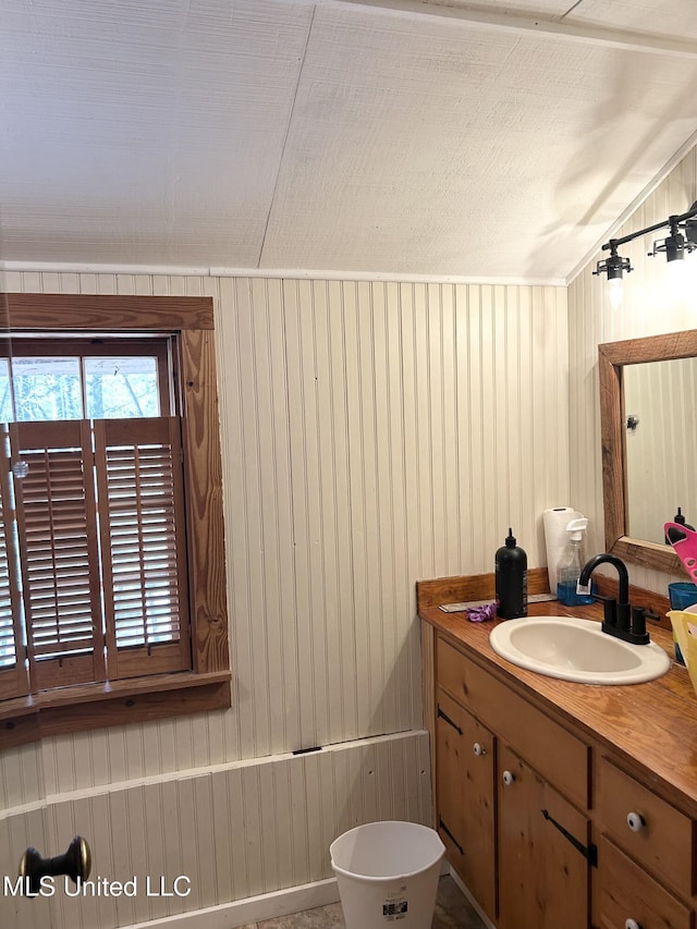 bathroom featuring wooden walls and vanity