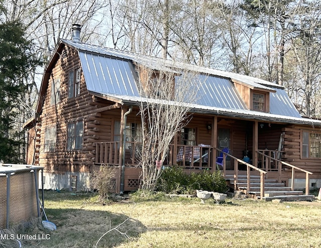 cabin featuring covered porch, a front lawn, and cooling unit