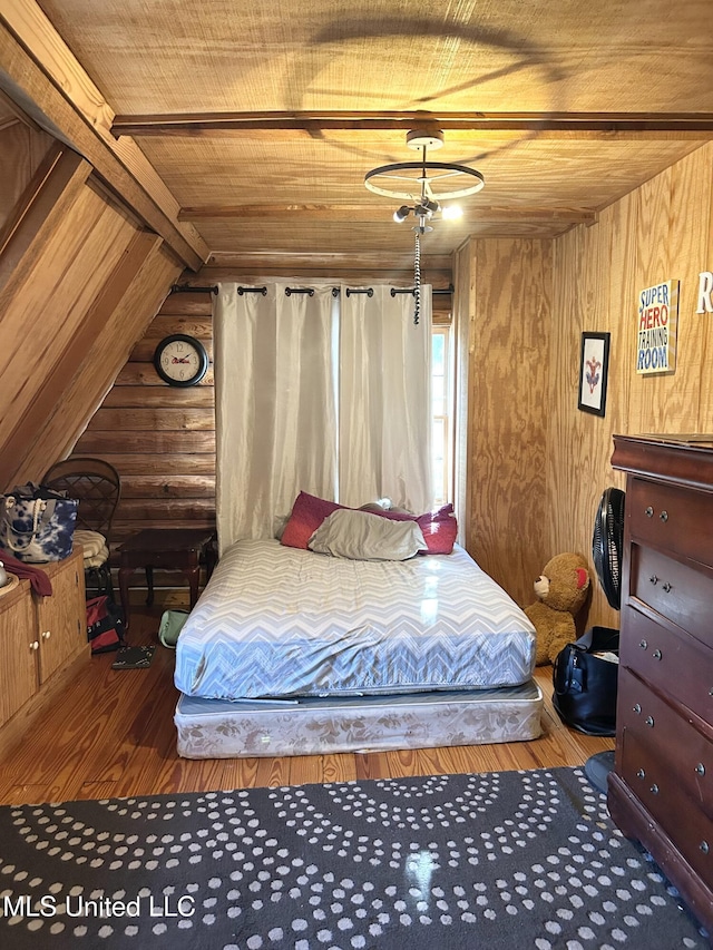 bedroom featuring lofted ceiling, wood walls, wood-type flooring, and wooden ceiling