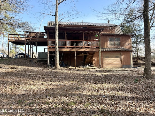 back of house with a deck and a garage